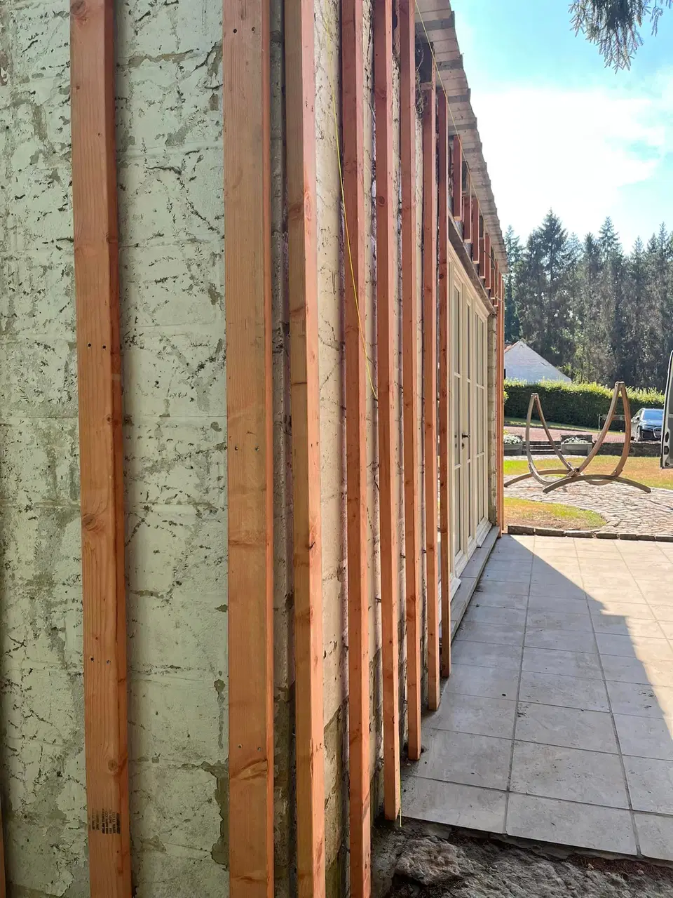 Une annexe de pierre habillée de clins horizontaux — au début du chantier