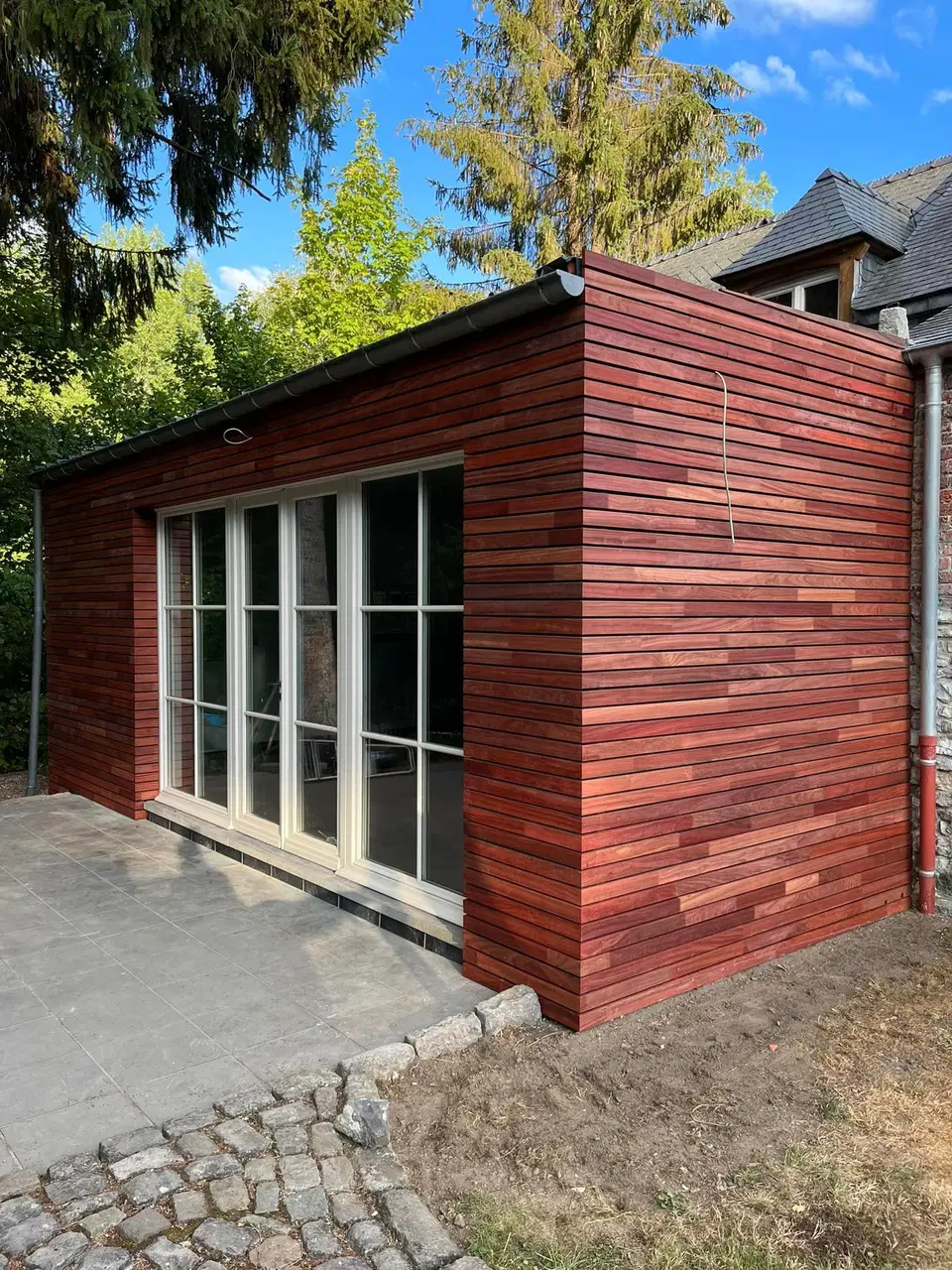 Une annexe de pierre habillée de clins horizontaux — pendant les travaux