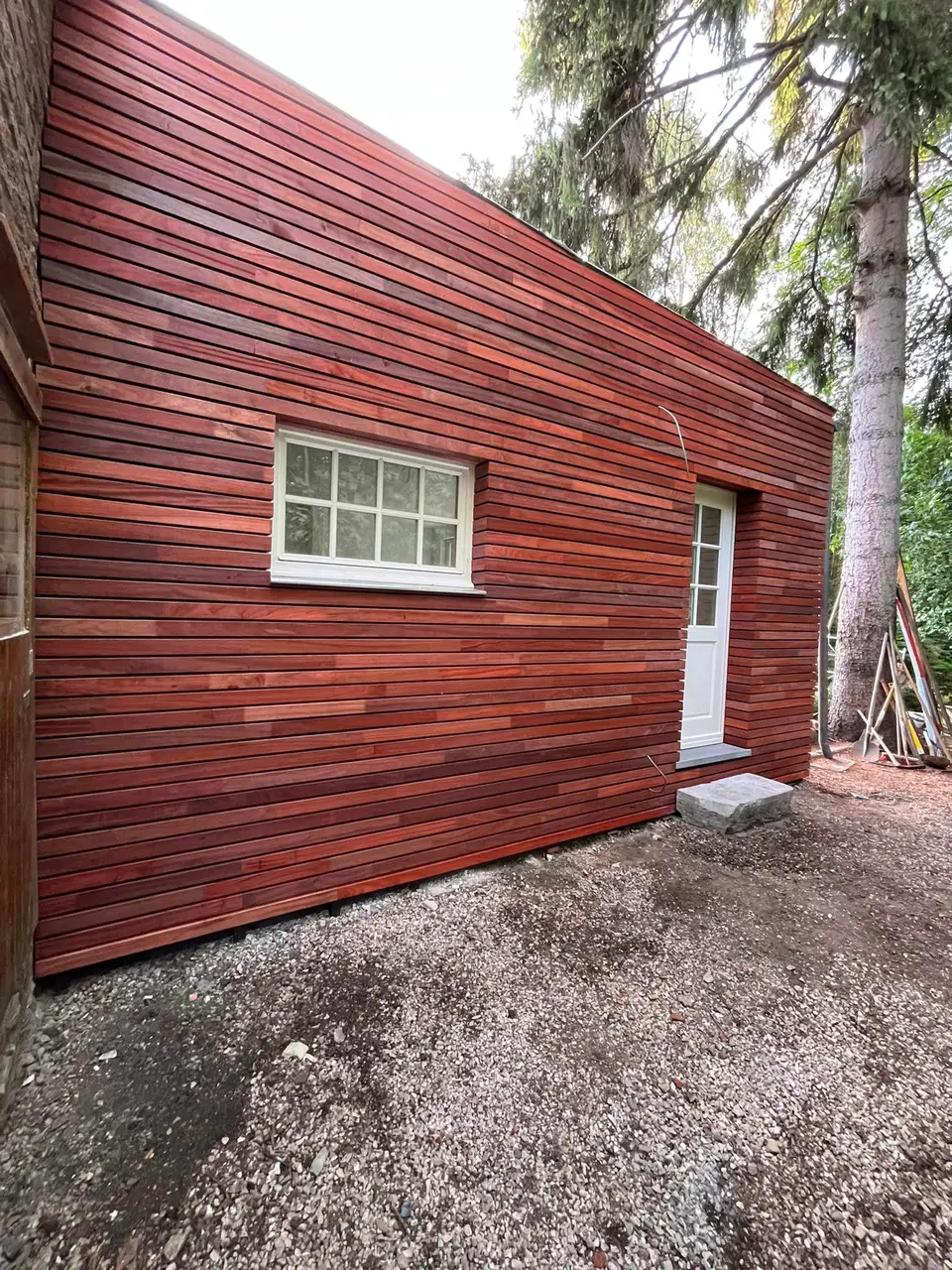 Une annexe de pierre habillée de clins horizontaux — vers la fin du chantier