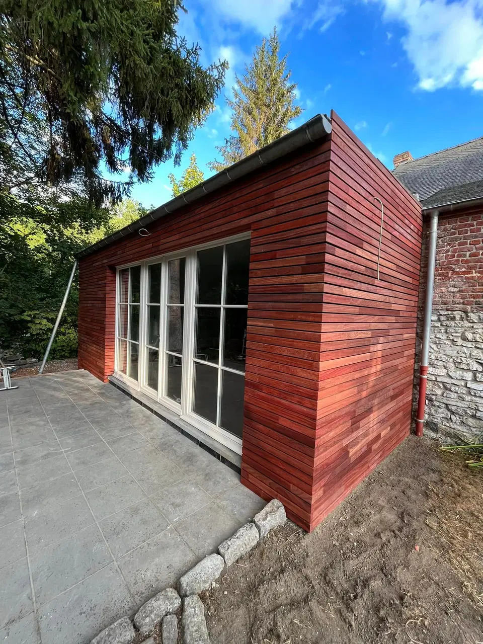 Une annexe de pierre habillée de clins horizontaux — en fin de chantier