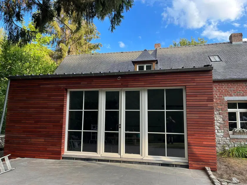 Une annexe de pierre habillée de clins horizontaux