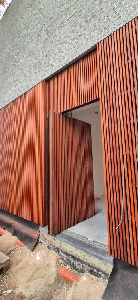 Bardage vertical en padouk 25 × 25 — au début du chantier