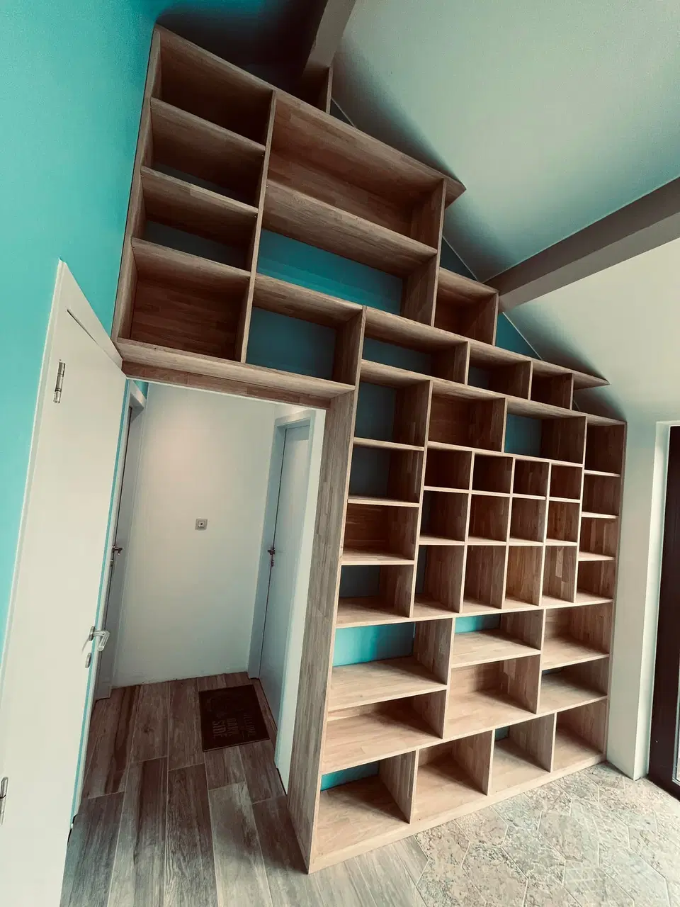 Une bibliothèque à casiers, suivant la pente du toit — pendant les travaux