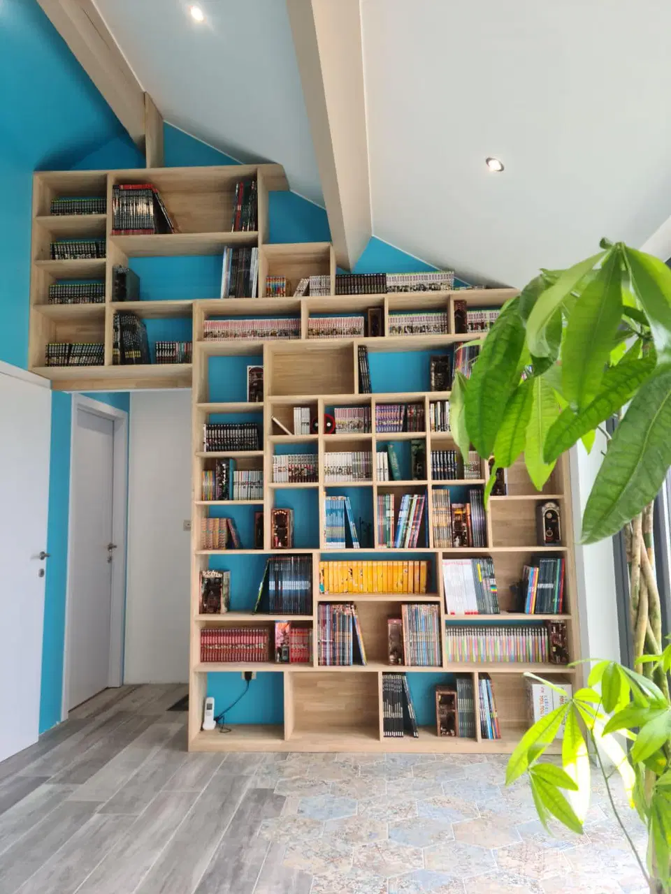 Une bibliothèque à casiers, suivant la pente du toit — en fin de chantier