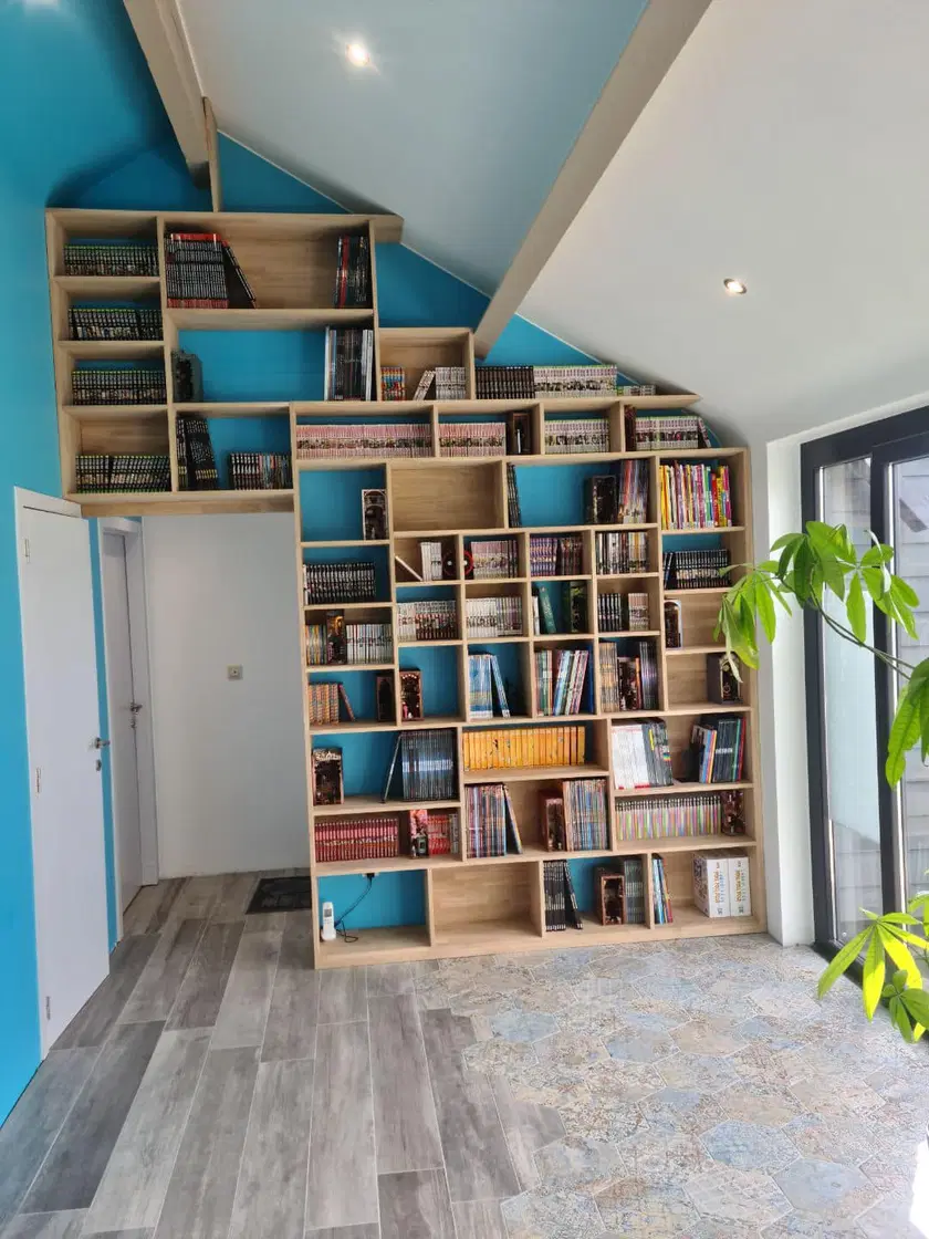 Une bibliothèque à casiers, suivant la pente du toit