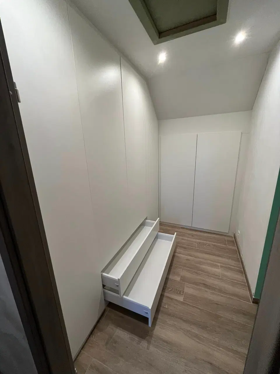 Un dressing blanc d'angle, toute hauteur — vers la fin du chantier