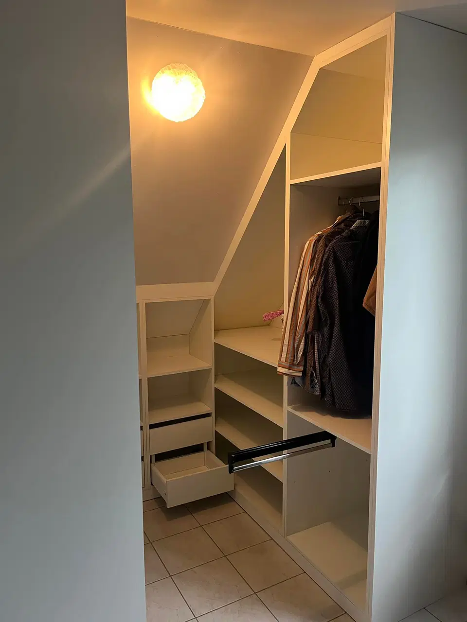 Un dressing ouvert sous comble, éclairé au plafond — au début du chantier