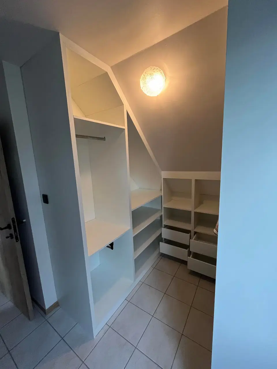 Un dressing ouvert sous comble, éclairé au plafond — vers la fin du chantier