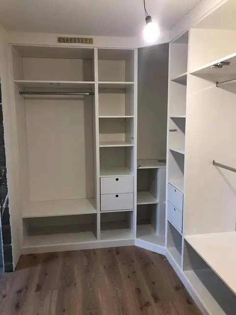 Un dressing sous comble, façades blanches et casiers — au début du chantier