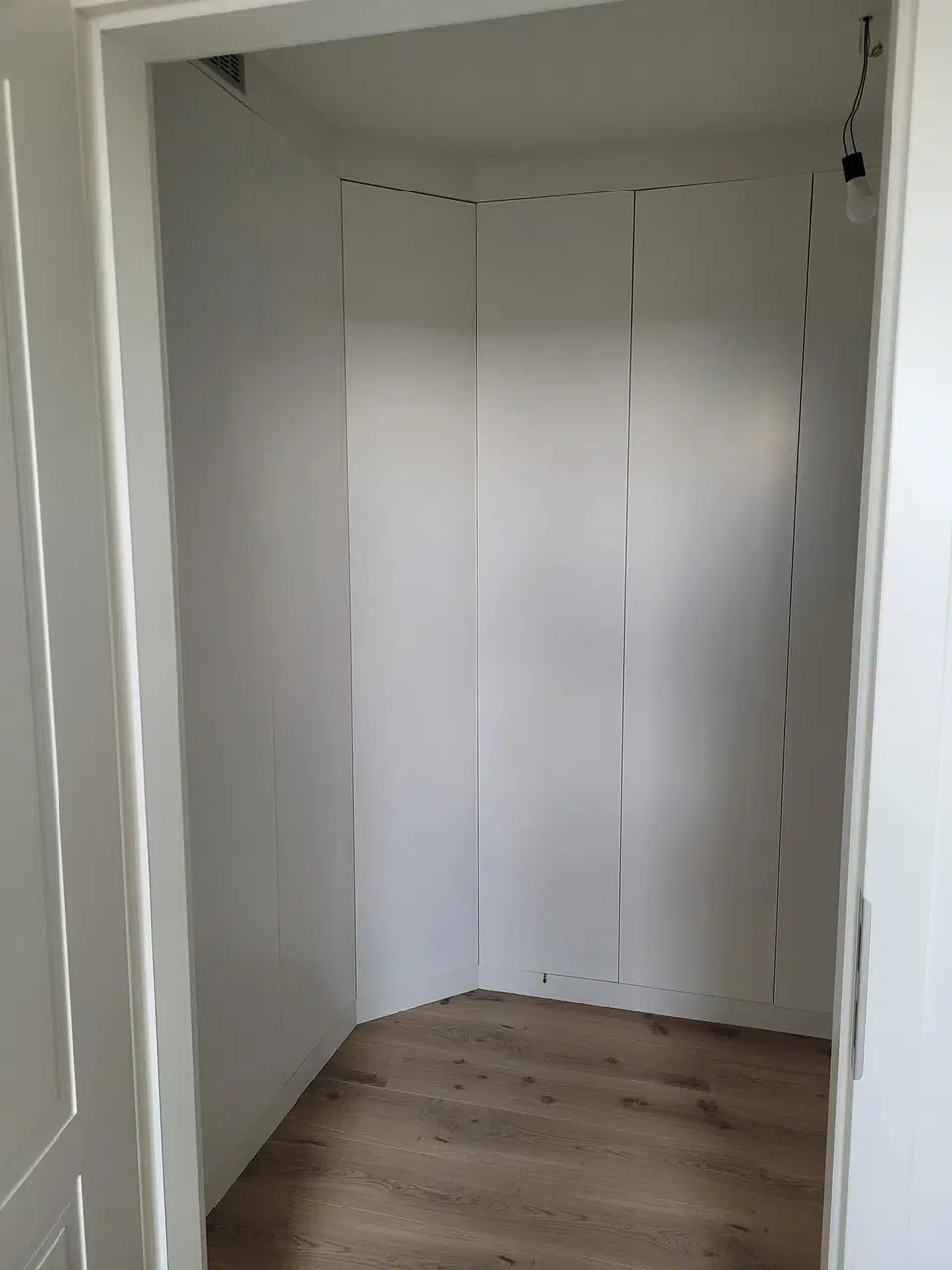 Un dressing sous comble, façades blanches et casiers — pendant les travaux