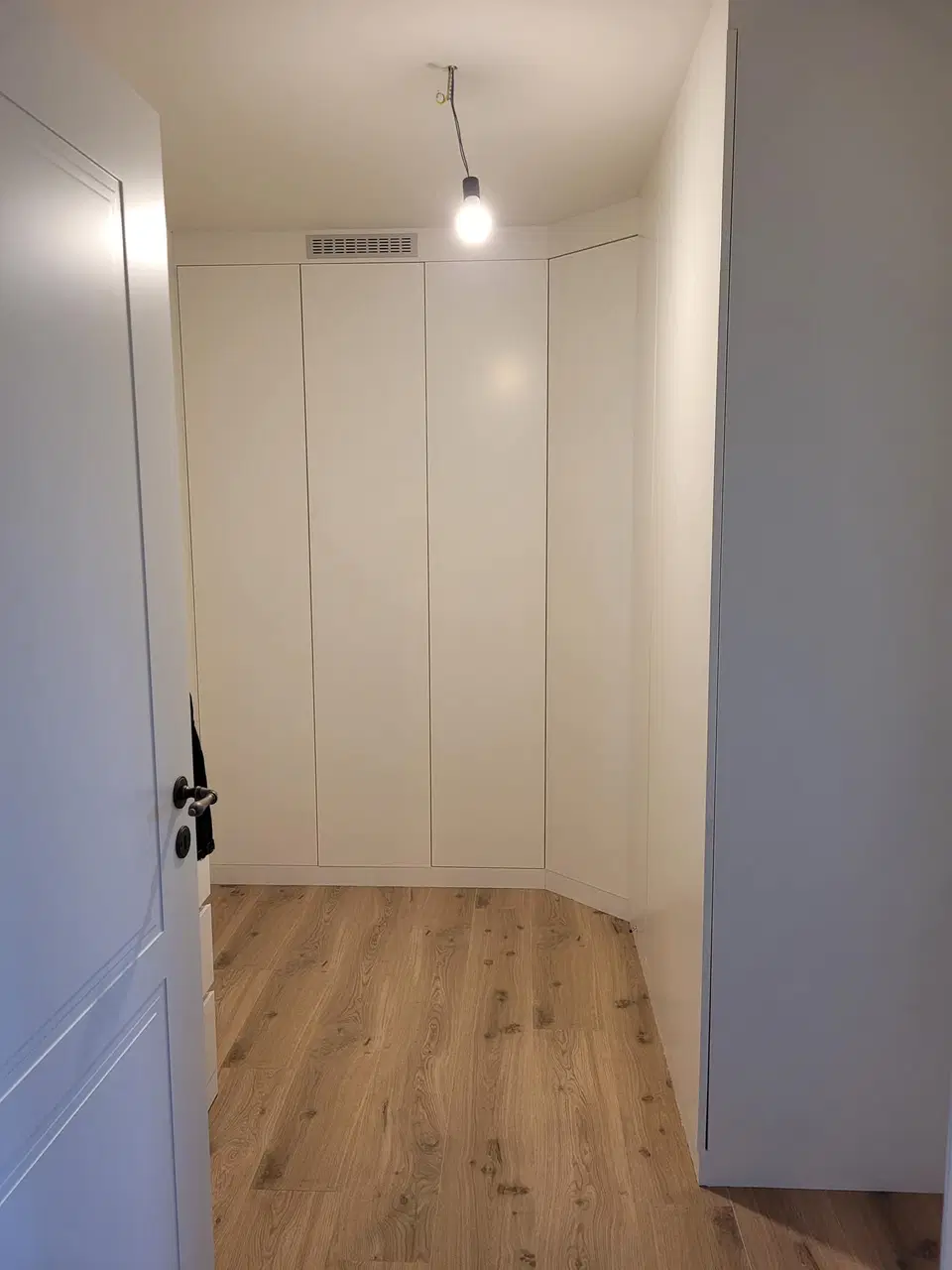 Un dressing sous comble, façades blanches et casiers — pendant les travaux