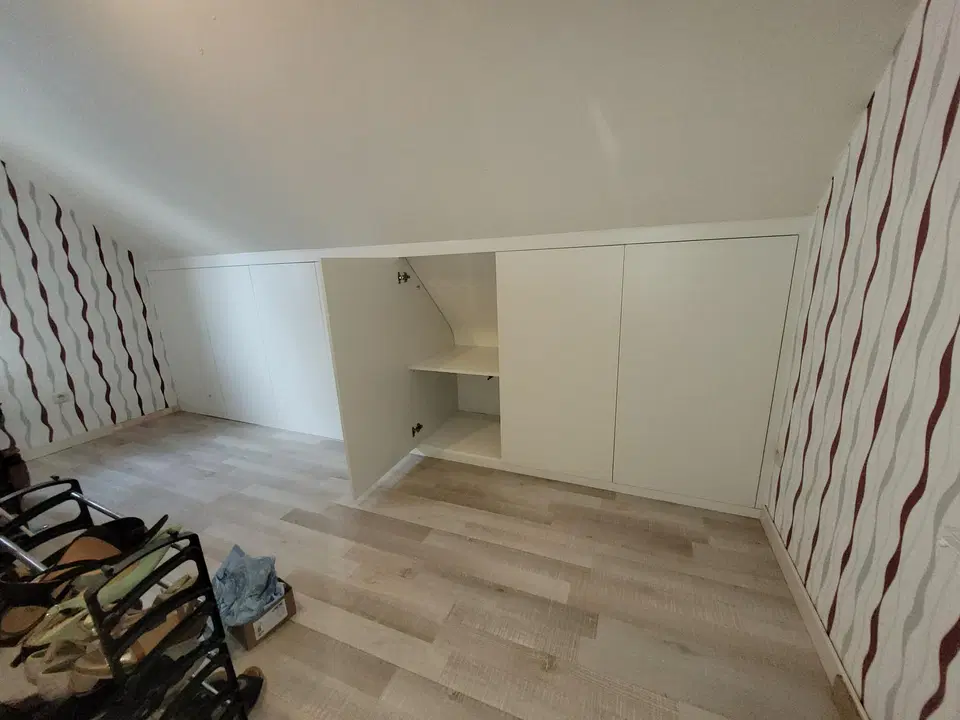 Un dressing sous comble, façades blanches et casiers — vers la fin du chantier