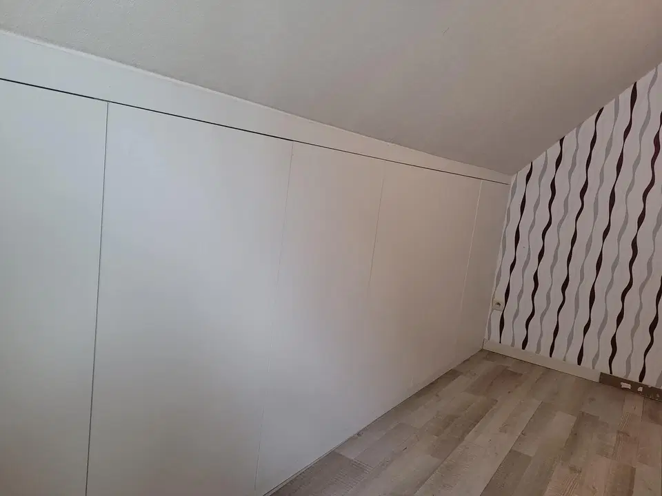 Un dressing sous comble, façades blanches et casiers — vers la fin du chantier