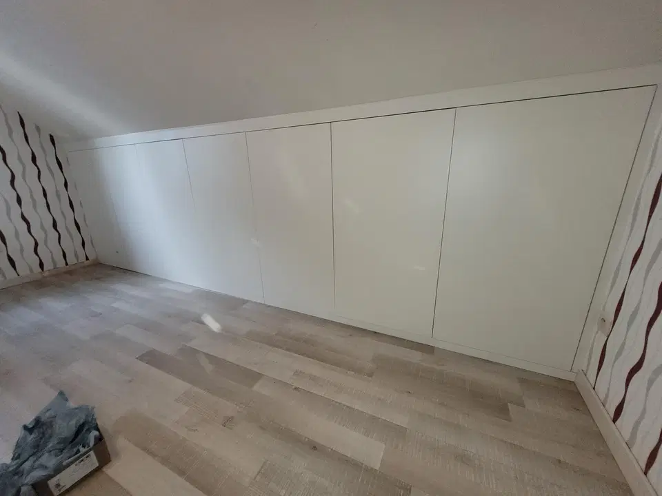 Un dressing sous comble, façades blanches et casiers — vers la fin du chantier