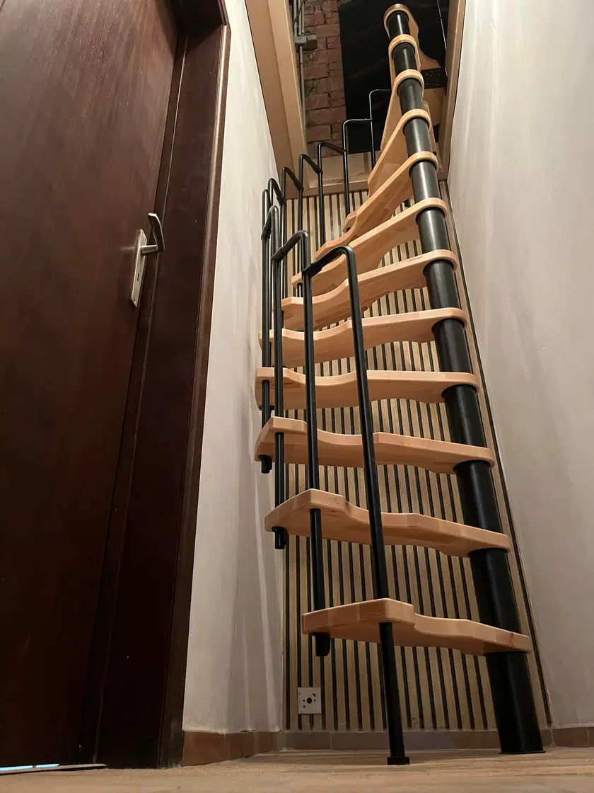 Un escalier a limon metallique et marches de bois