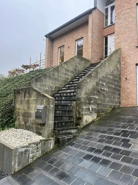 L’escalier extérieur en béton avant travaux, avec son mur de soutènement brut