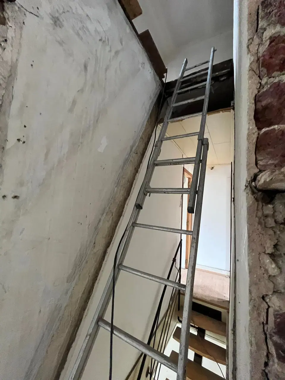 Un escalier de bois brut dans une maison en rénovation — au début du chantier