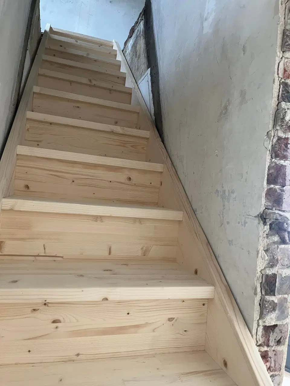 Un escalier de bois brut dans une maison en rénovation — pendant les travaux
