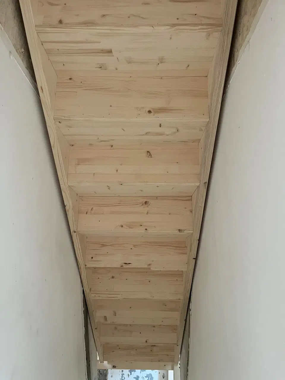Un escalier de bois brut dans une maison en rénovation — vers la fin du chantier