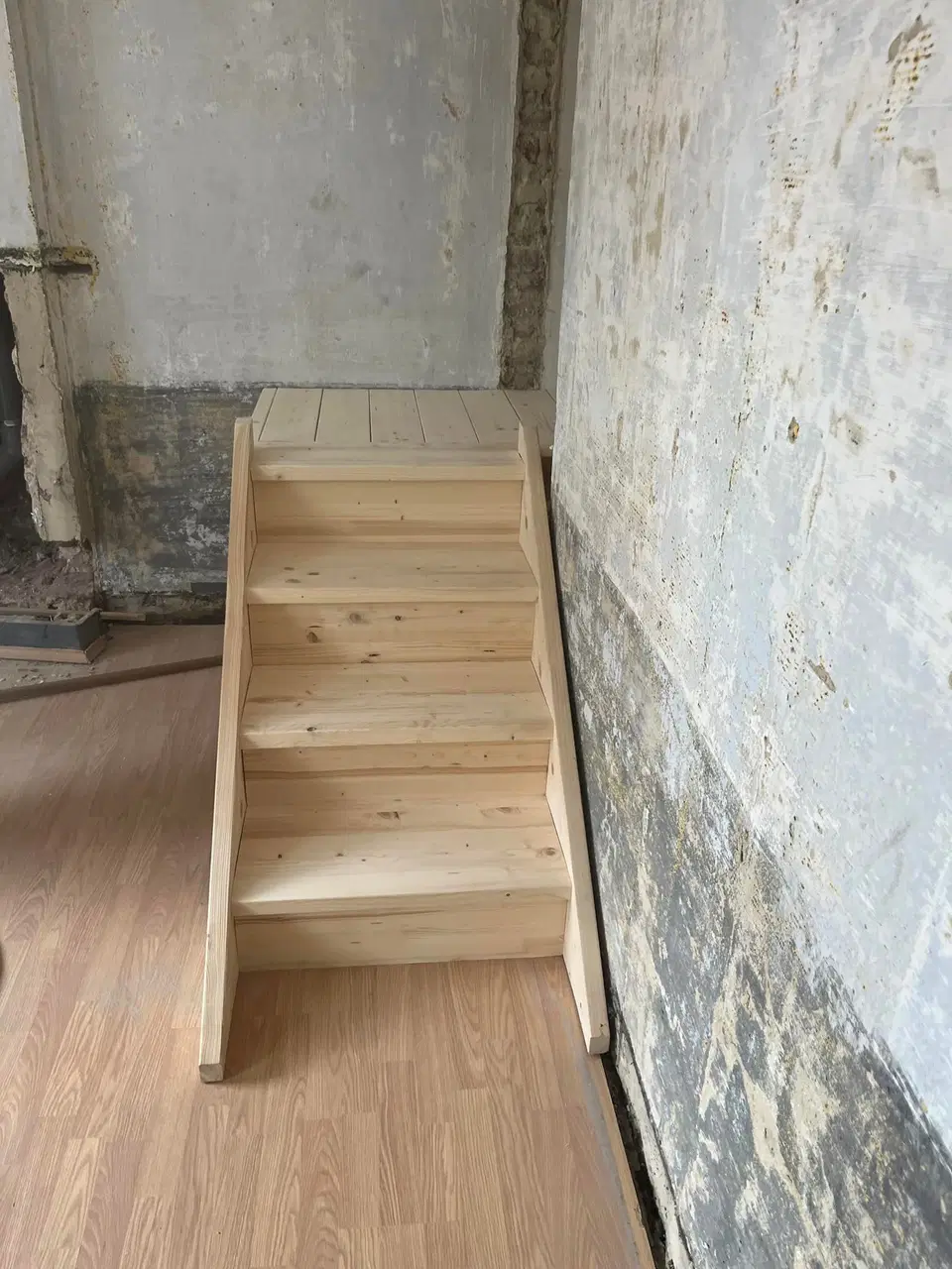 Un escalier de bois brut dans une maison en rénovation — en fin de chantier