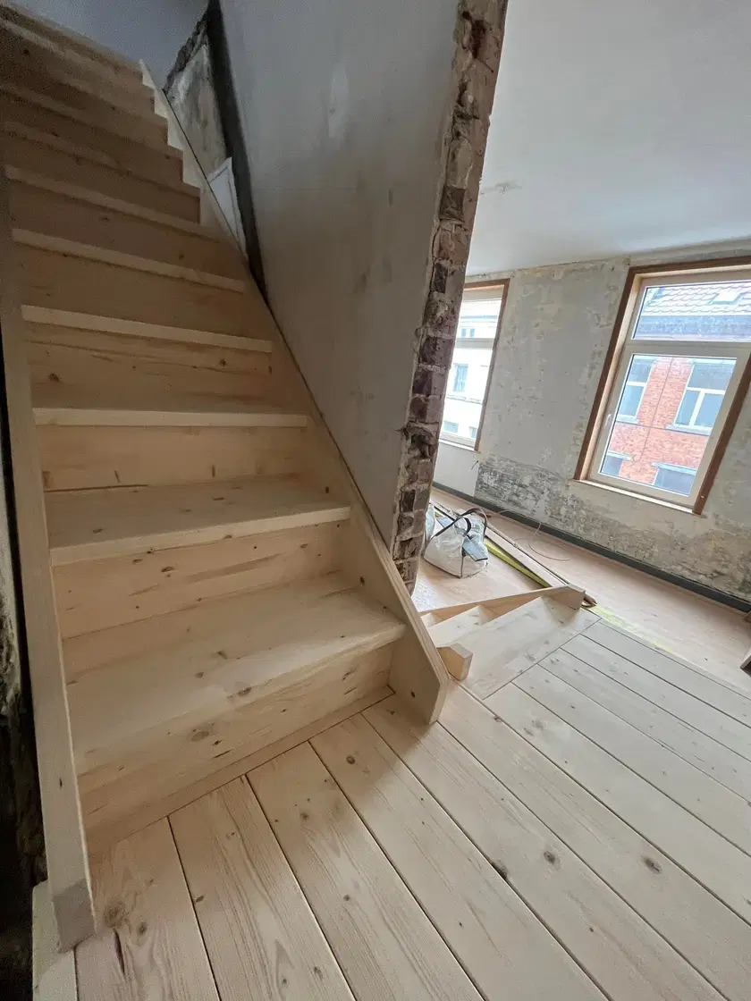 Un escalier de bois brut dans une maison en rénovation