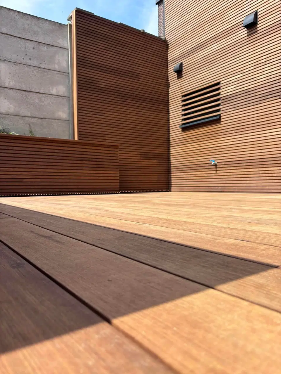L’angle de la terrasse : les lames du platelage filent vers le bardage, sans seuil ni rupture