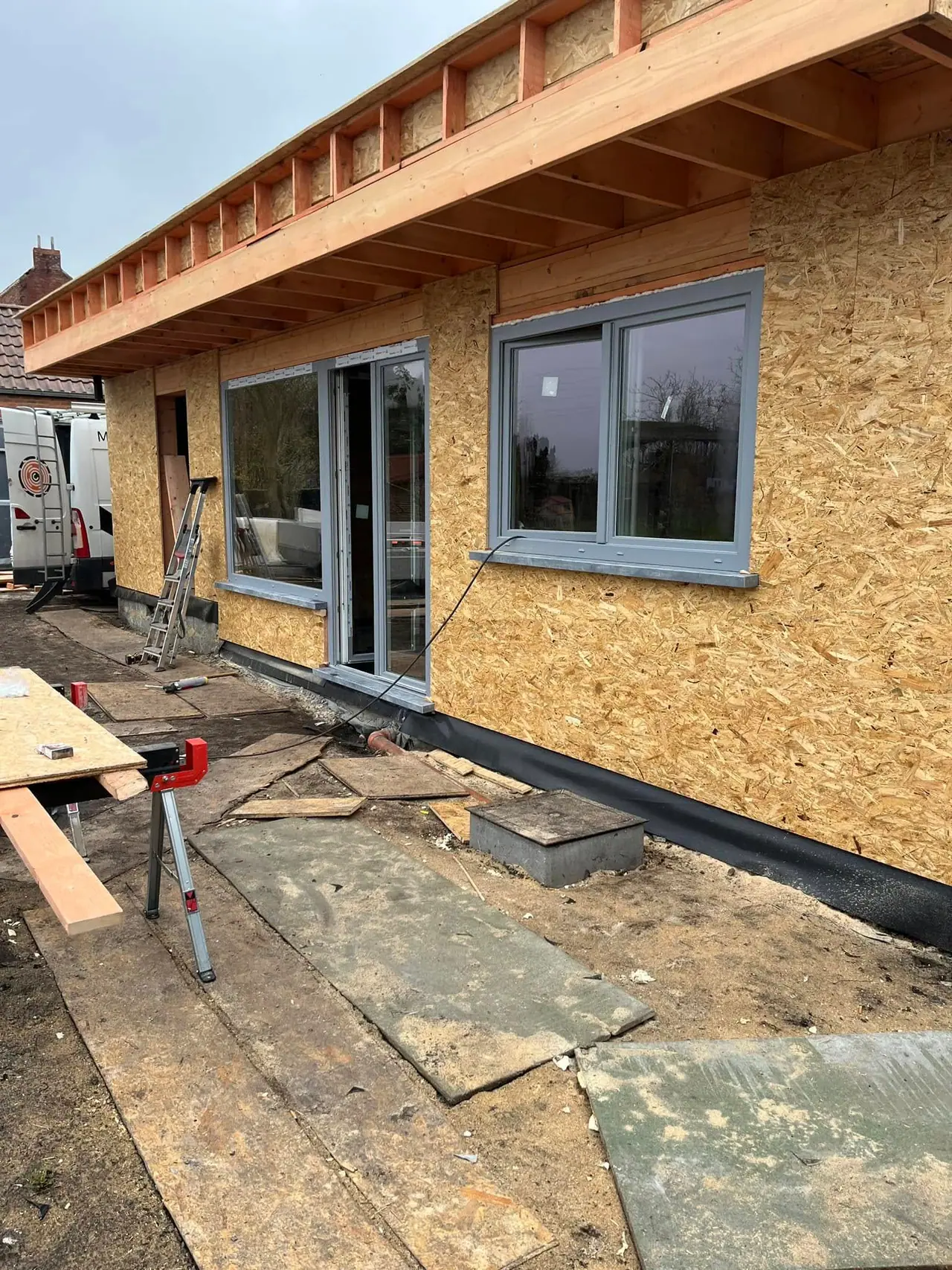 Mur en OSB, fenêtre posée et rive de toit en bois, en plein soleil