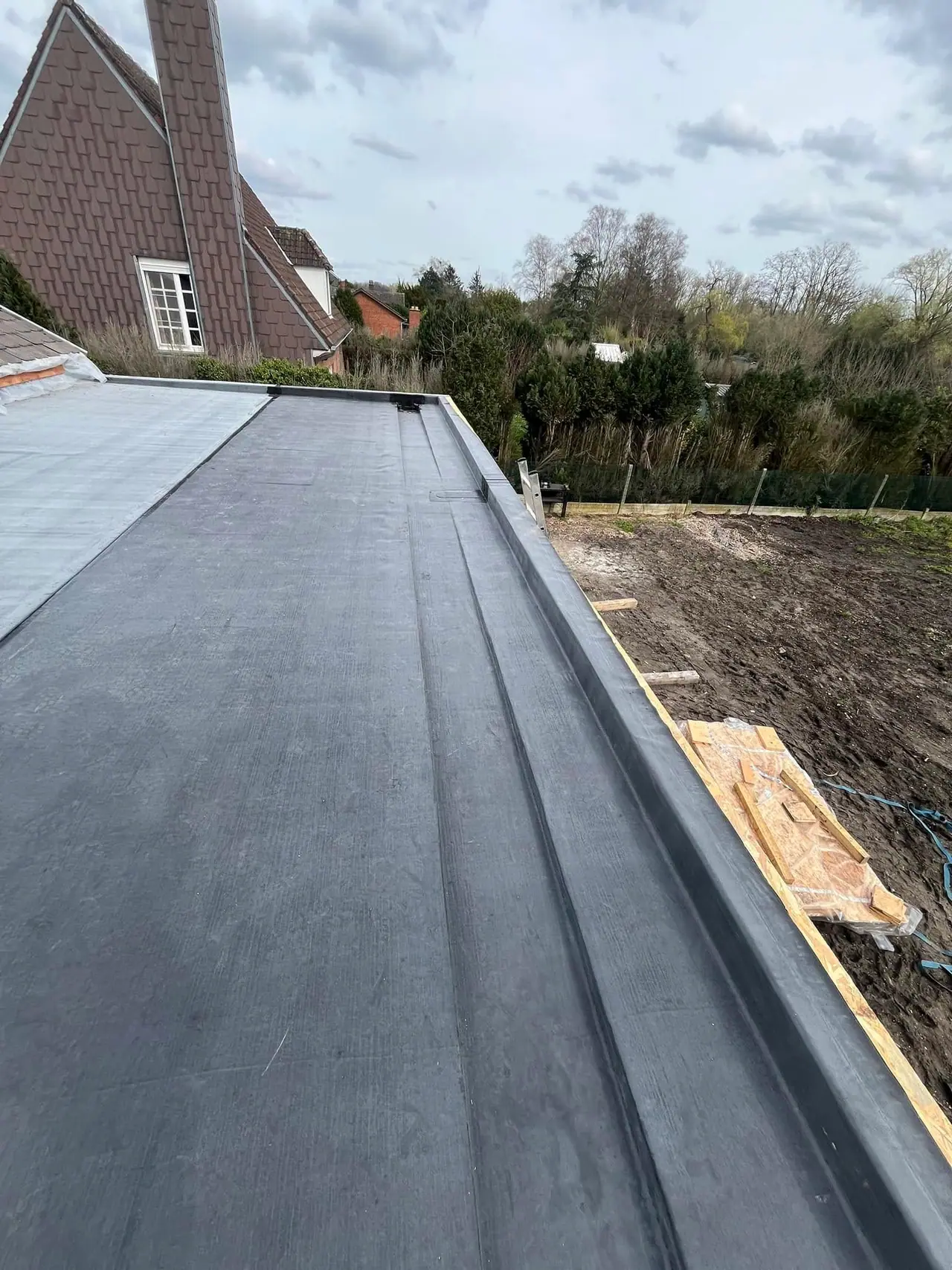 La toiture plate terminée : étanchéité EPDM et acrotère, vue en longueur