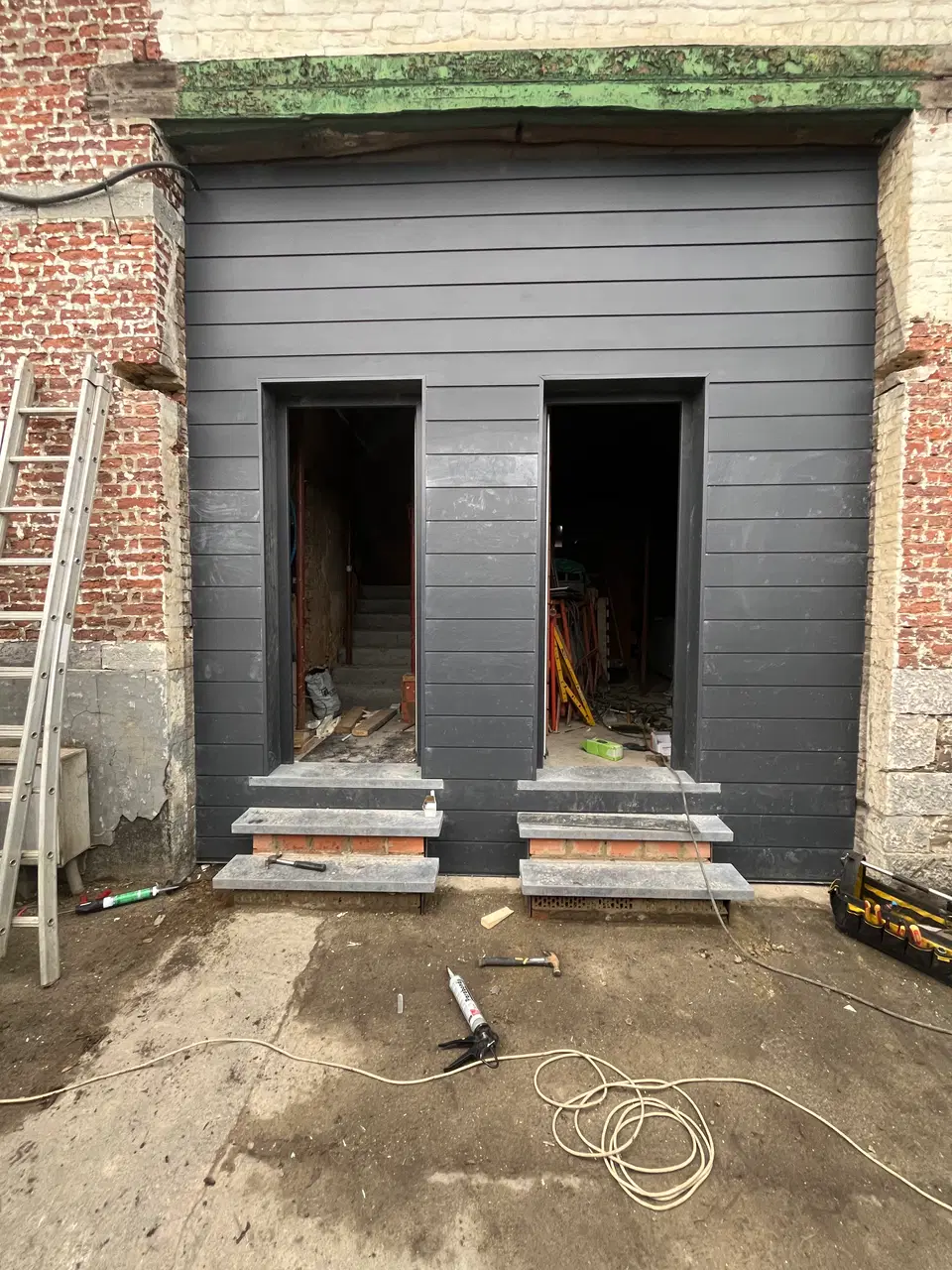 Une façade de bâti ancien rhabillée en fibres-ciment — au début du chantier