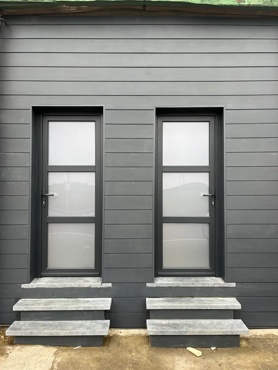 Une façade de bâti ancien rhabillée en fibres-ciment — vers la fin du chantier