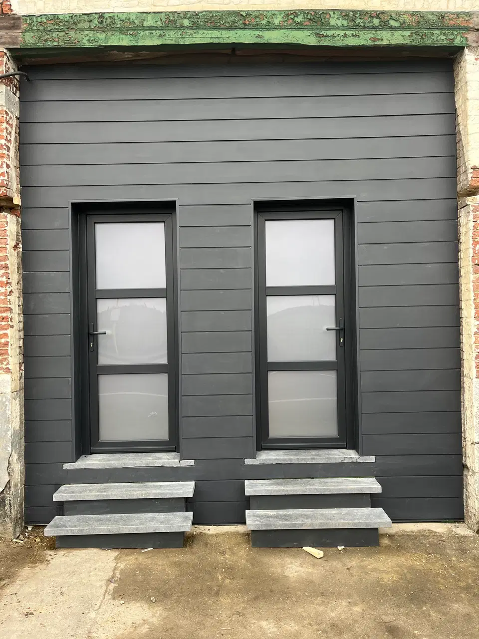 Une façade de bâti ancien rhabillée en fibres-ciment — vers la fin du chantier
