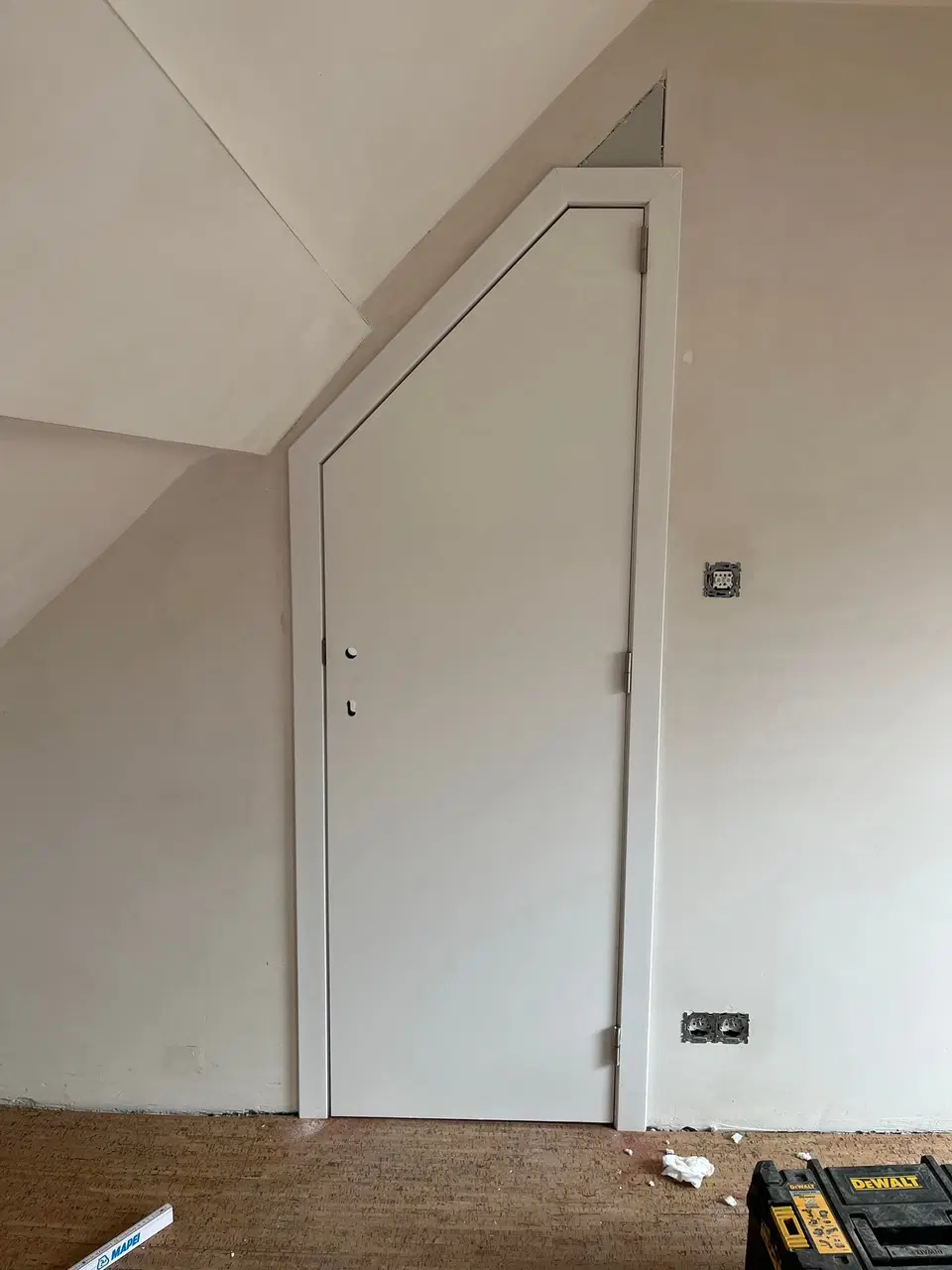 Un habillage de murs sous comble, panneaux blancs — au début du chantier