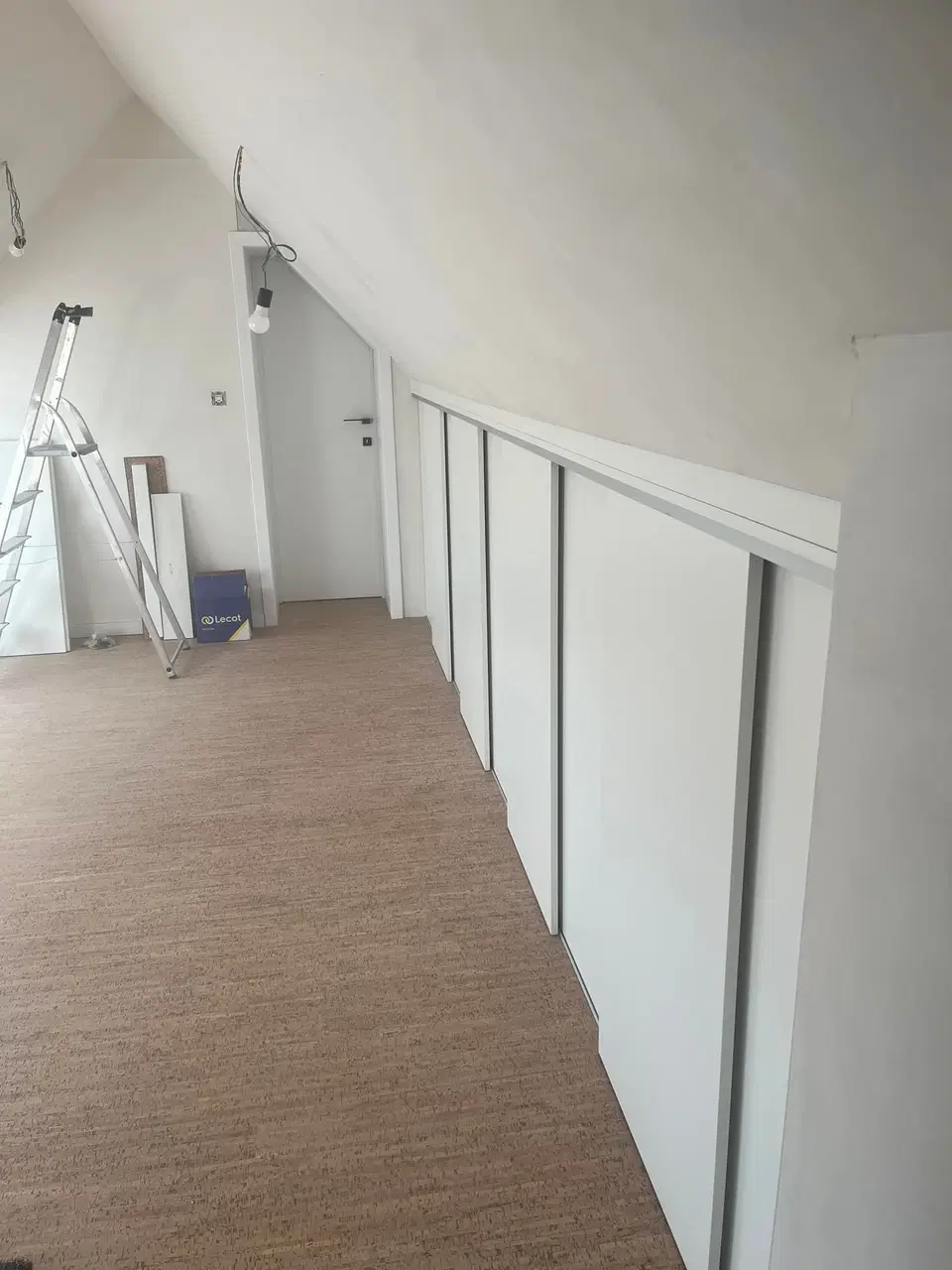 Un habillage de murs sous comble, panneaux blancs — pendant les travaux