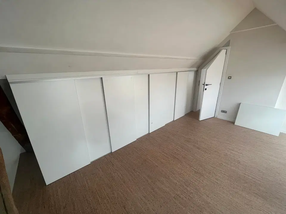 Un habillage de murs sous comble, panneaux blancs — en fin de chantier