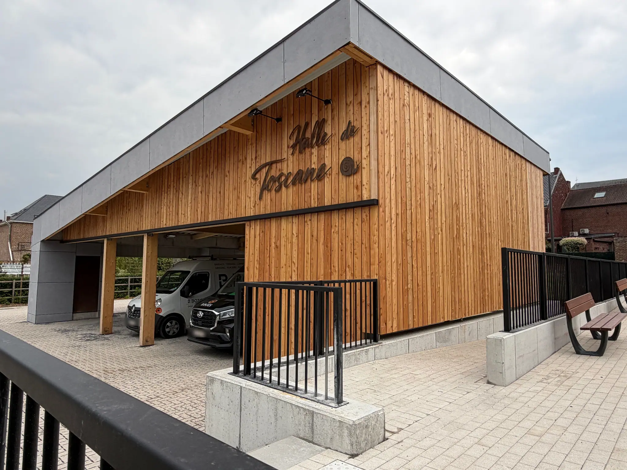 La halle de Silly achevée : pignon en bardage de bois portant l’enseigne, parvis pavé et garde-corps posés