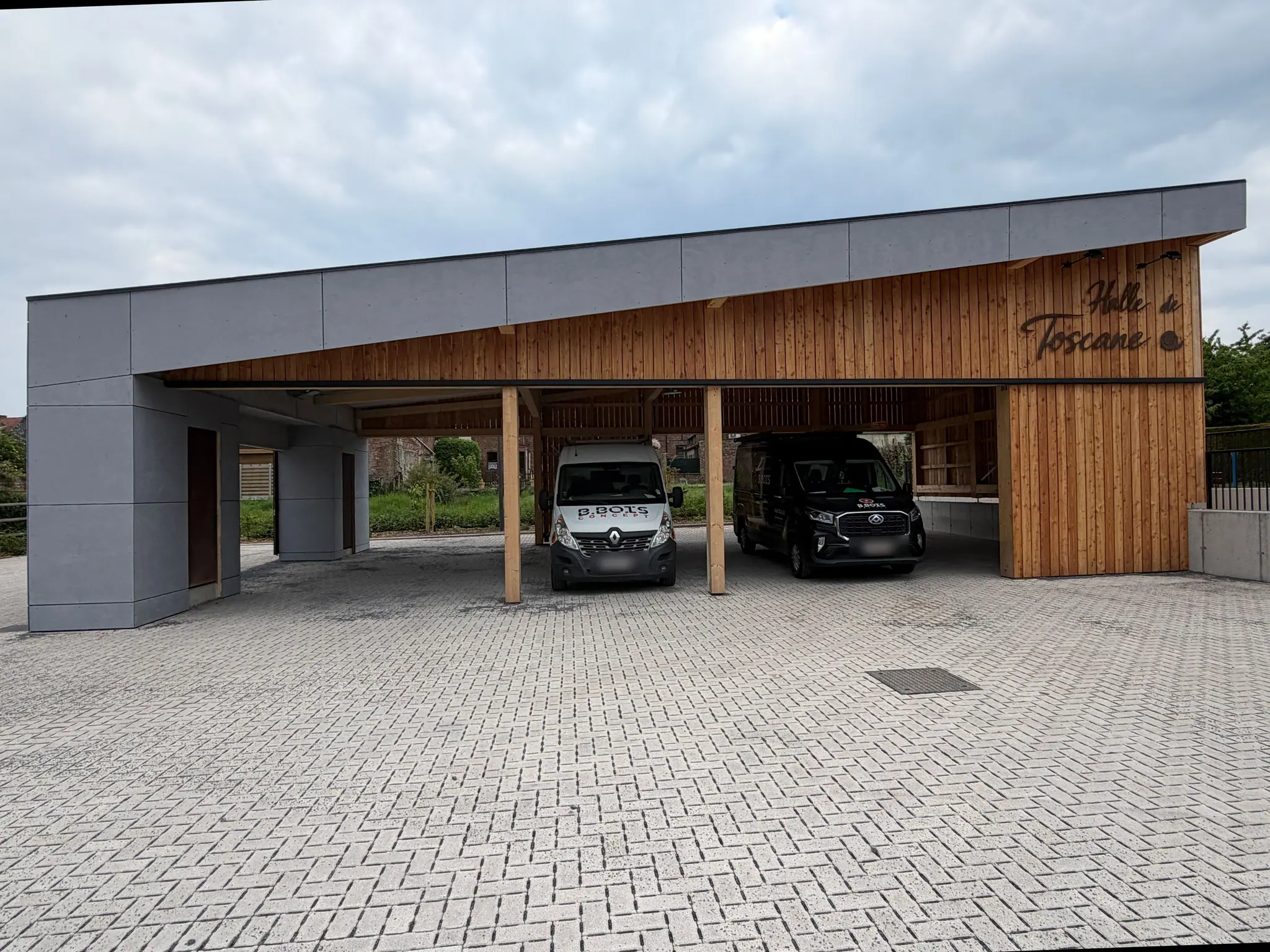 La halle communale de Silly achevée : charpente et bardage de bois réalisés par B-Bois-Concept, enseigne peinte sur le pignon et parvis pavé
