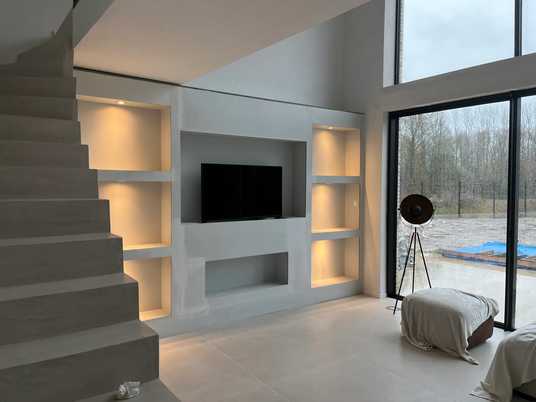 Le meuble en place, niches rétroéclairées allumées et écran encastré, au pied de l’escalier