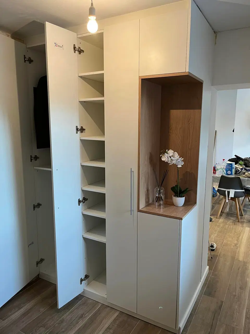 Un mur de placards blancs à niche de bois — pendant les travaux