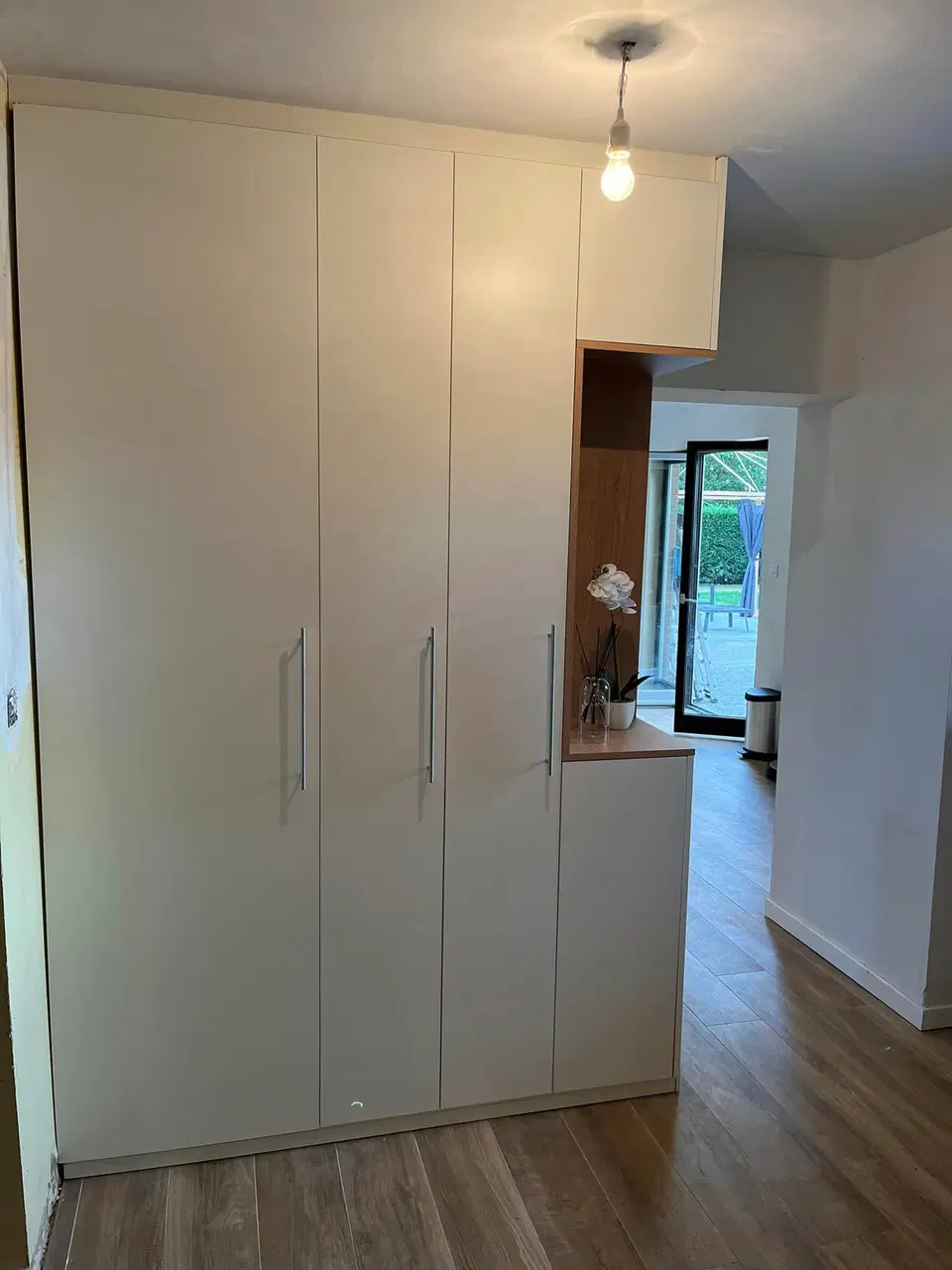 Un mur de placards blancs à niche de bois — vers la fin du chantier