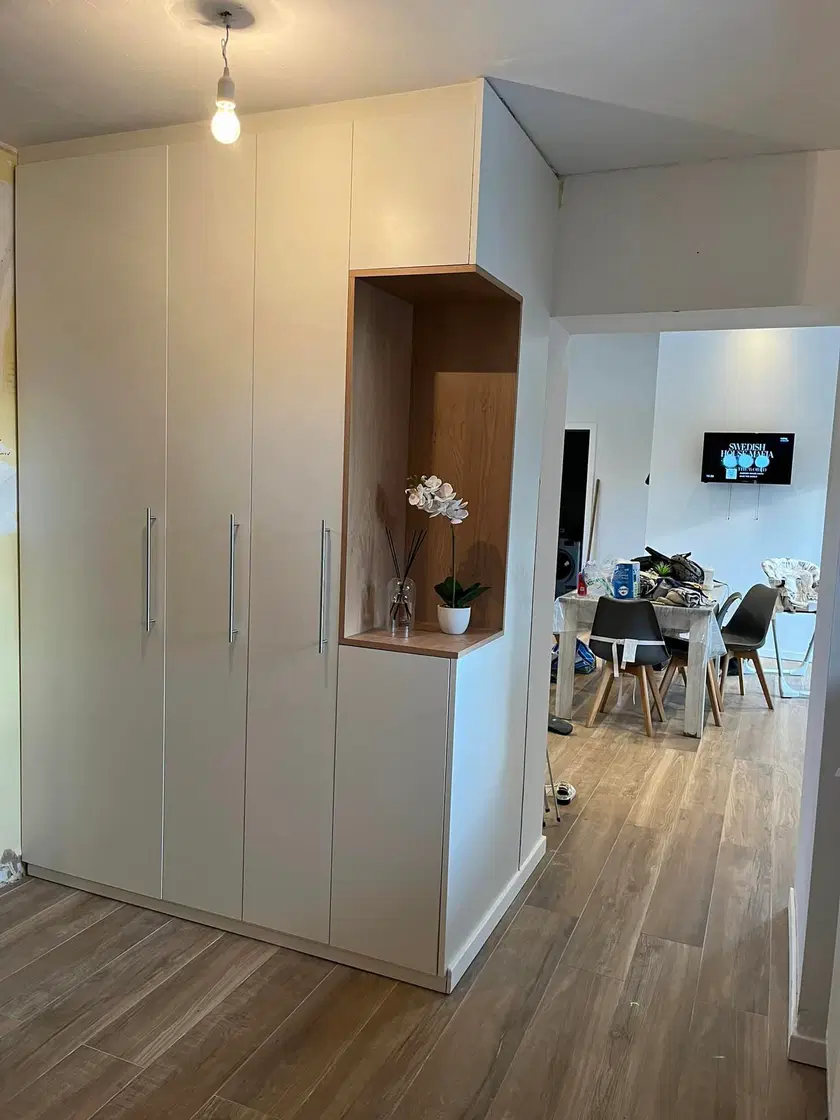 Un mur de placards blancs à niche de bois