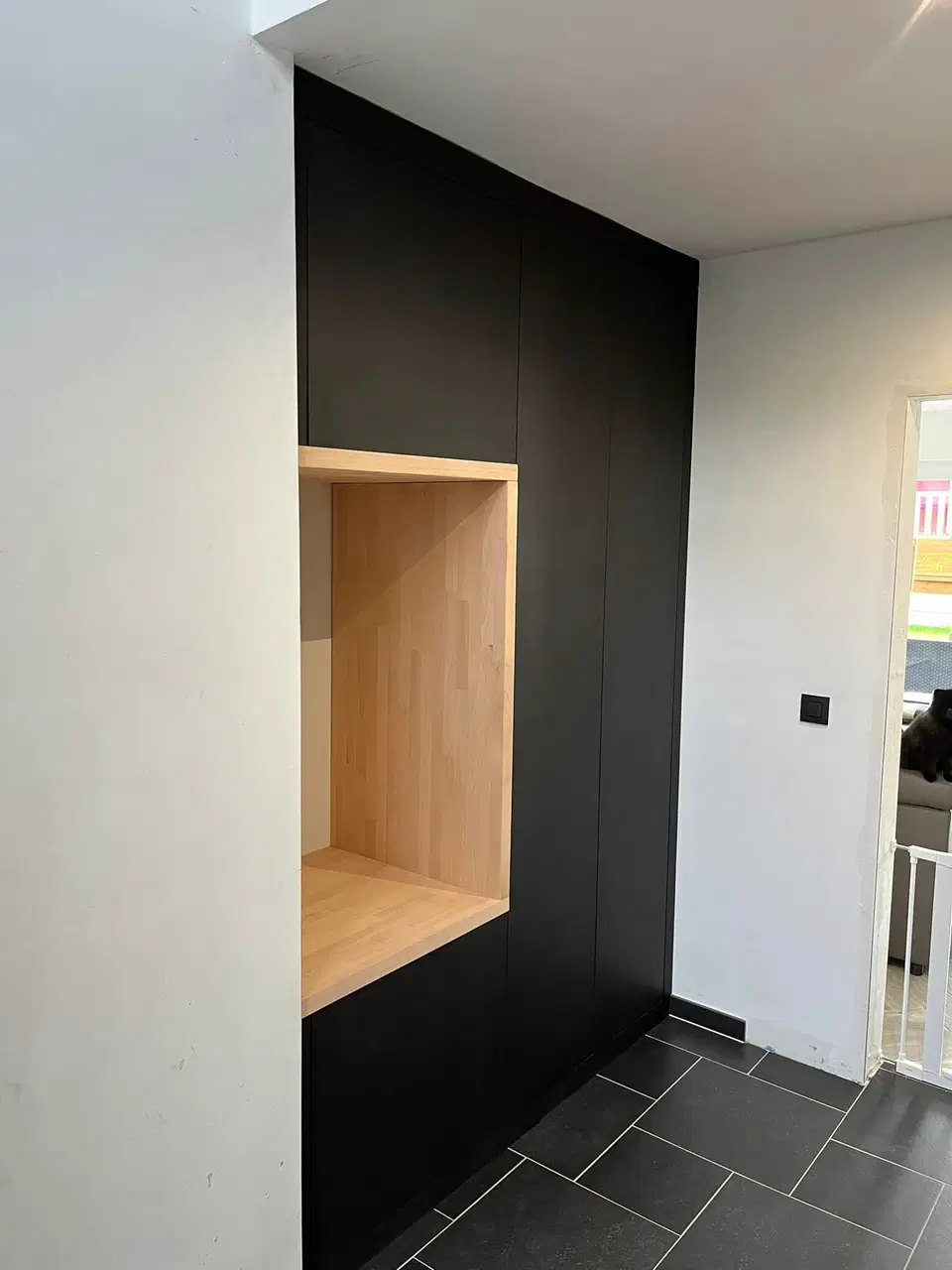 Un mur noir a niches de bois — vers la fin du chantier