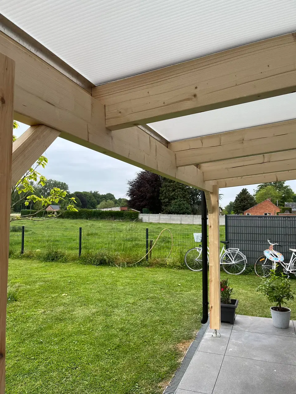 Une pergola adossée, couverture translucide — vers la fin du chantier