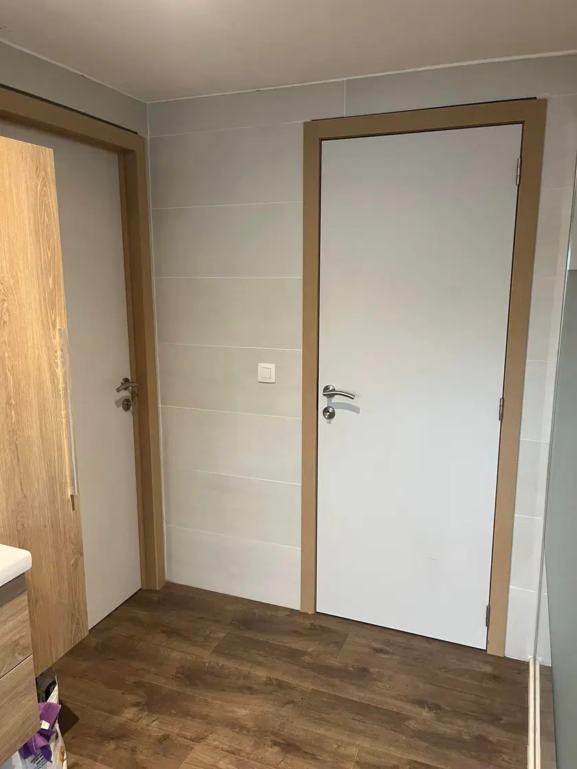 Des portes intérieures blanches à chambranles de bois