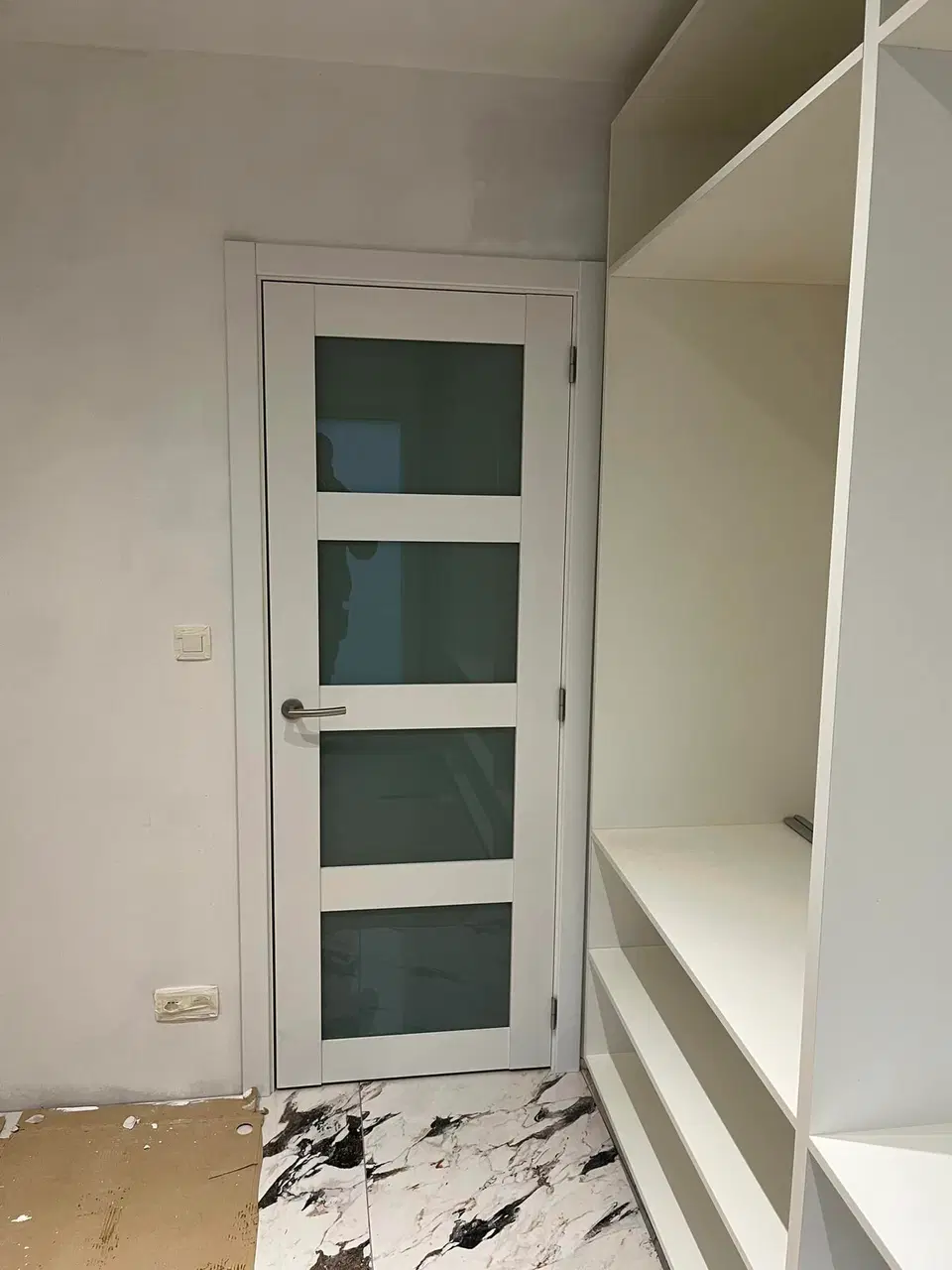 Des portes interieures vitrees, blanches — vers la fin du chantier