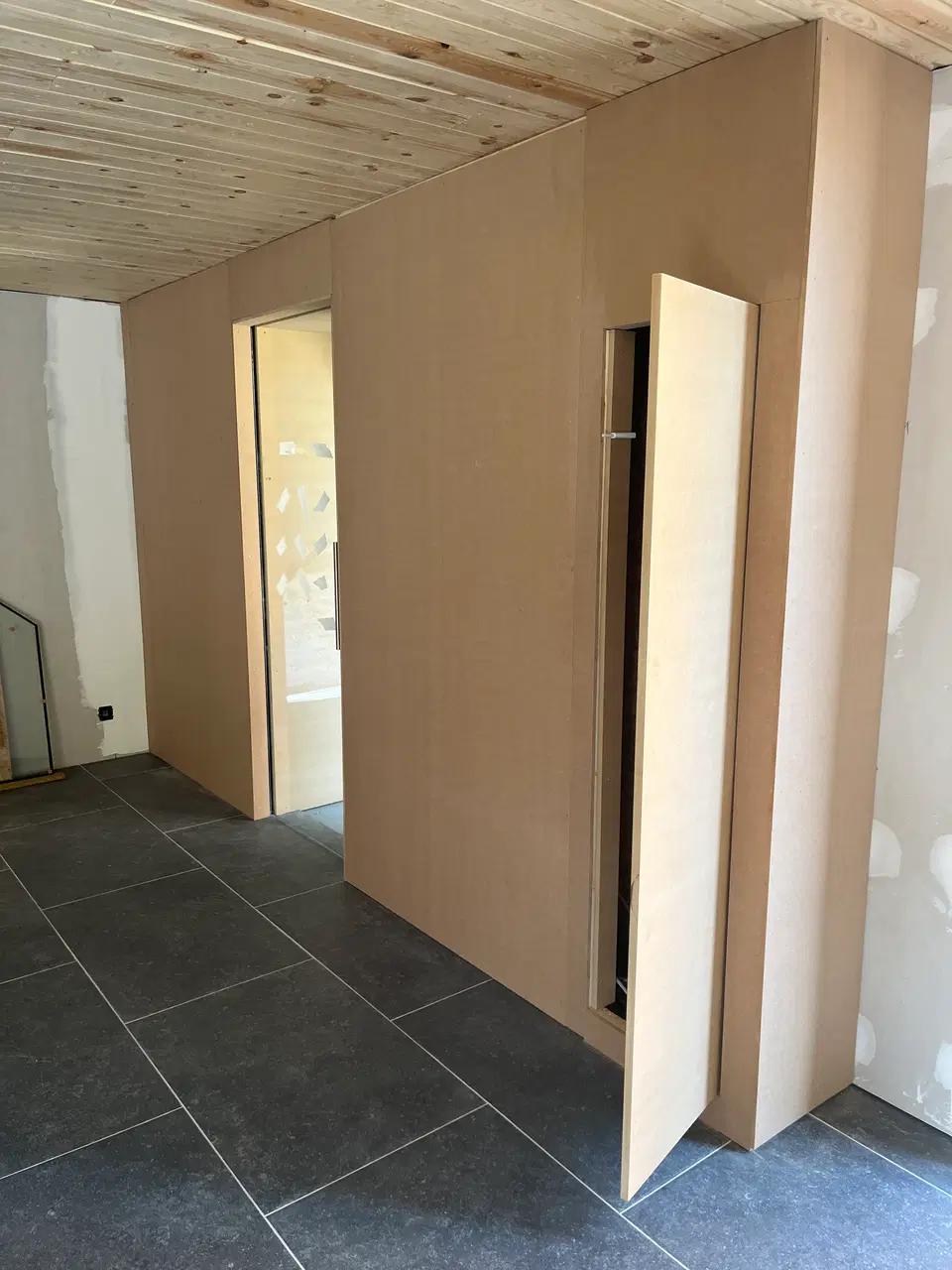 Des portes toute hauteur, à peine visibles dans le mur — pendant les travaux