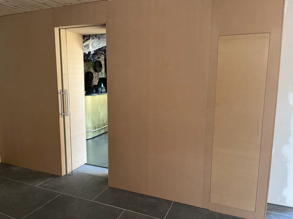 Des portes toute hauteur, à peine visibles dans le mur — vers la fin du chantier