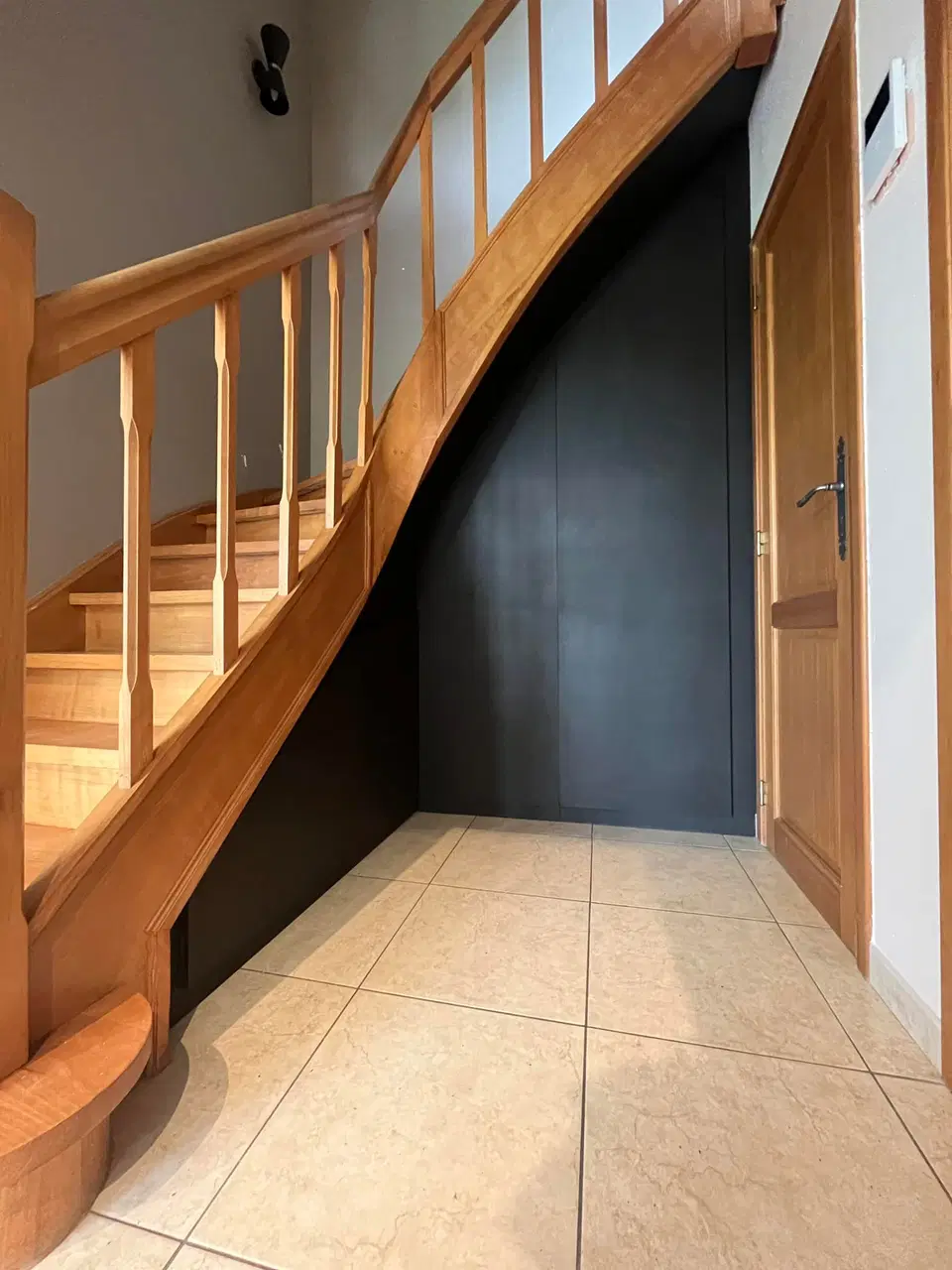 Un rangement sous escalier, portes sombres