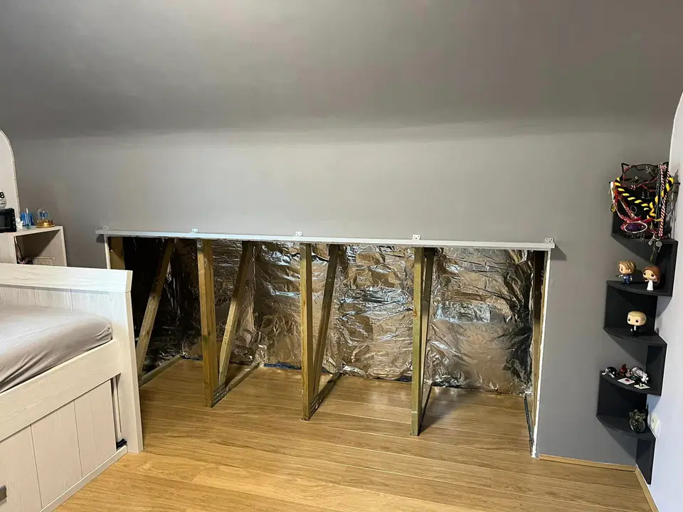 Des rangements bas sous pente, dans une chambre — au début du chantier