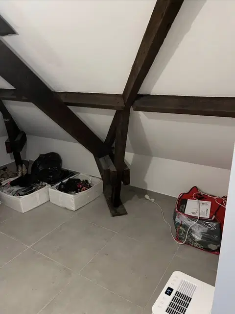 Rangements sous combles autour d’une charpente apparente — pendant les travaux
