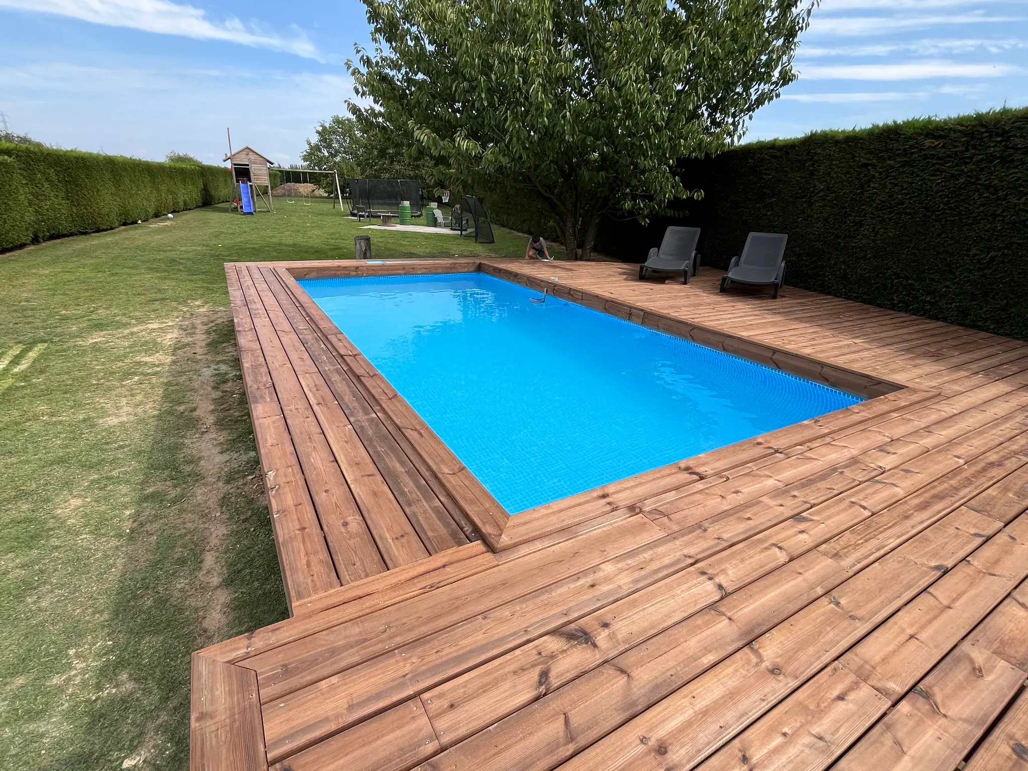 Le bassin depuis le fond du jardin : le platelage file vers la cour et l’emmarchement
